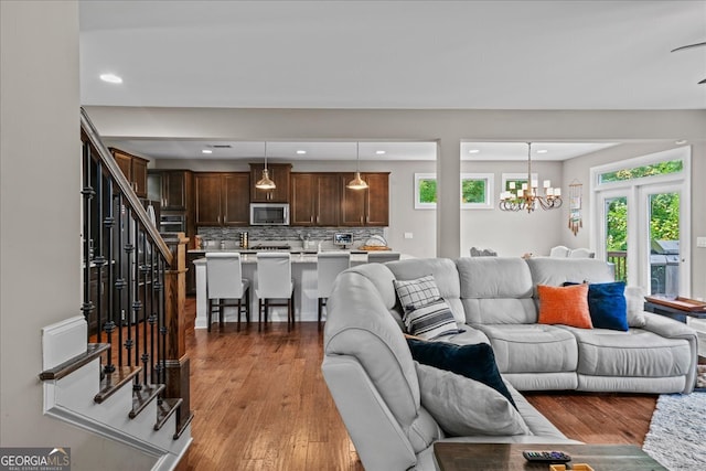 living room with french doors, wood-type flooring, and a chandelier