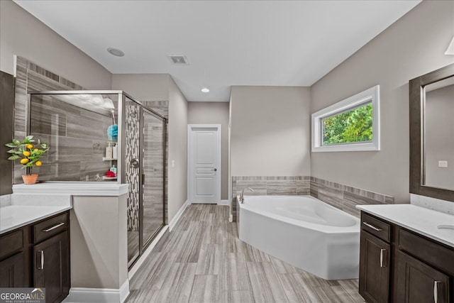 bathroom featuring vanity, wood-type flooring, and shower with separate bathtub