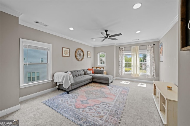 carpeted living room with ceiling fan and crown molding