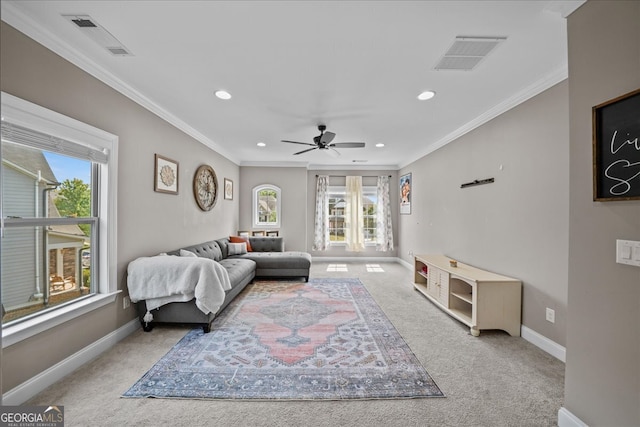 living room with ceiling fan, crown molding, and light carpet