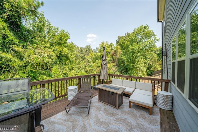 exterior space featuring a wooden deck and an outdoor living space with a fire pit