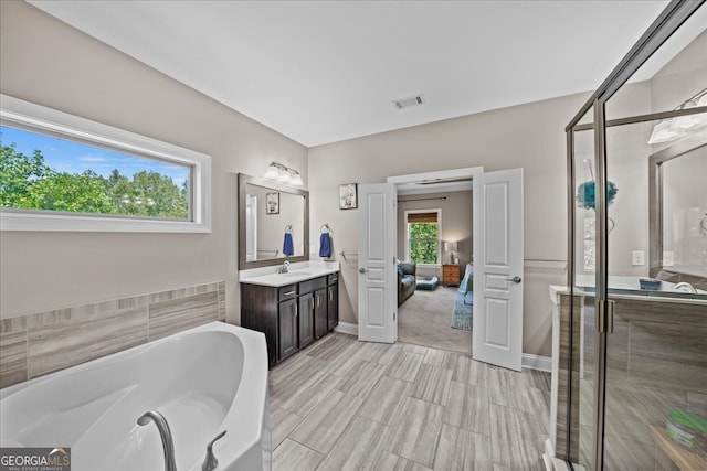 bathroom featuring vanity and independent shower and bath