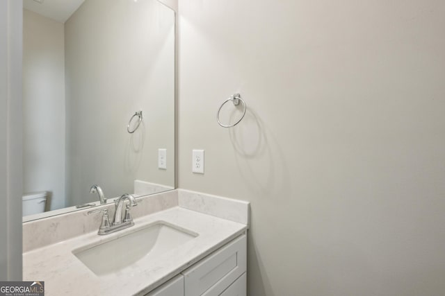 half bathroom with vanity and toilet