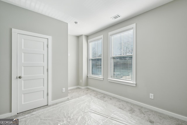 unfurnished room with visible vents and baseboards