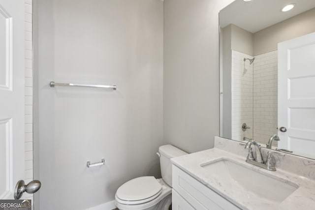 bathroom featuring toilet, baseboards, a shower, and vanity