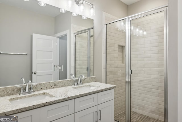 bathroom featuring a sink, a shower stall, and double vanity