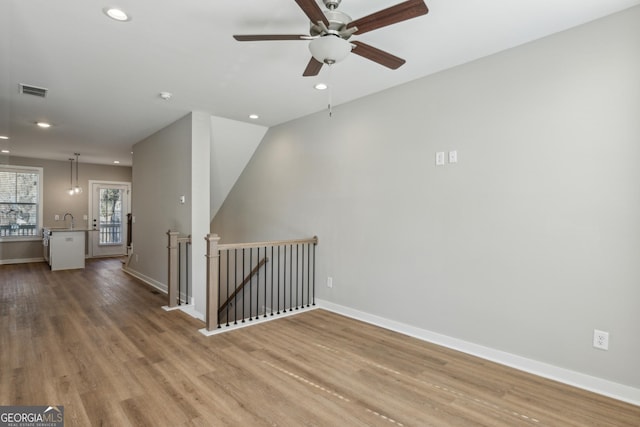 unfurnished room featuring recessed lighting, baseboards, and wood finished floors