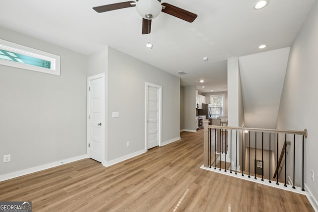 empty room with light wood-type flooring, baseboards, and recessed lighting