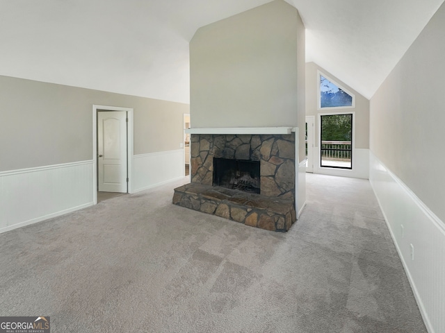 unfurnished living room with light colored carpet, vaulted ceiling, and a fireplace