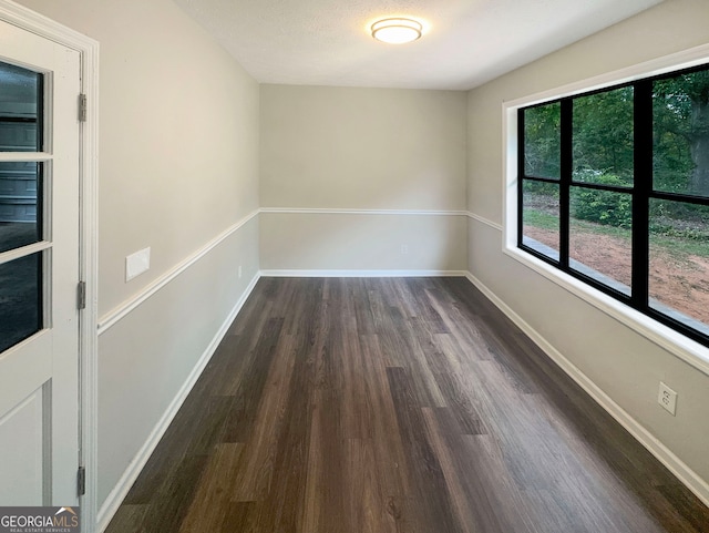 spare room featuring a textured ceiling and dark hardwood / wood-style floors