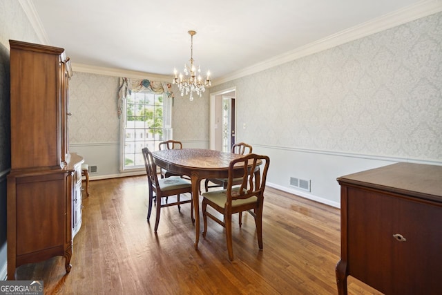 dining room with a chandelier, dark hardwood / wood-style flooring, and ornamental molding