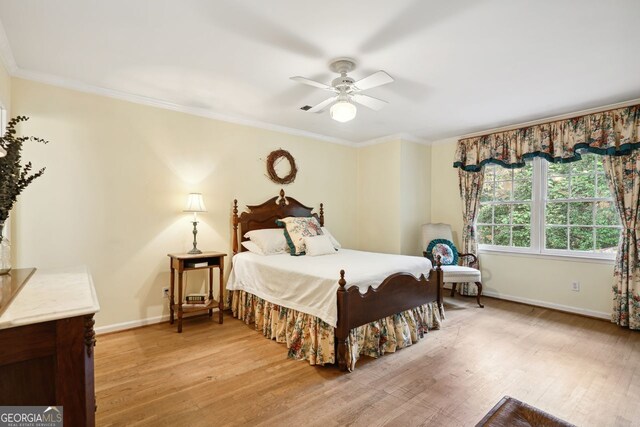 bedroom featuring ornamental molding, light hardwood / wood-style flooring, and ceiling fan