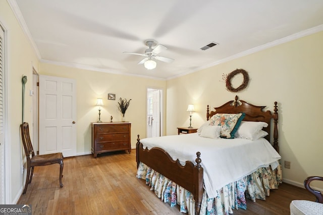 bedroom featuring ceiling fan, ornamental molding, and light hardwood / wood-style flooring