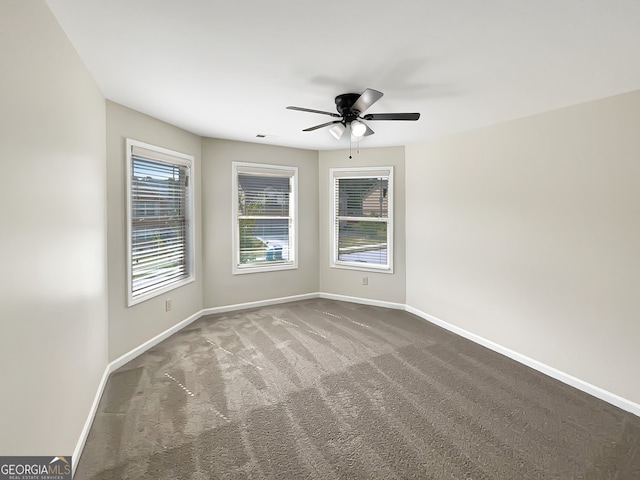 empty room with dark carpet and ceiling fan