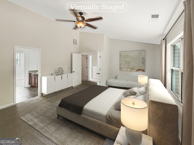 carpeted bedroom with ceiling fan, connected bathroom, and vaulted ceiling