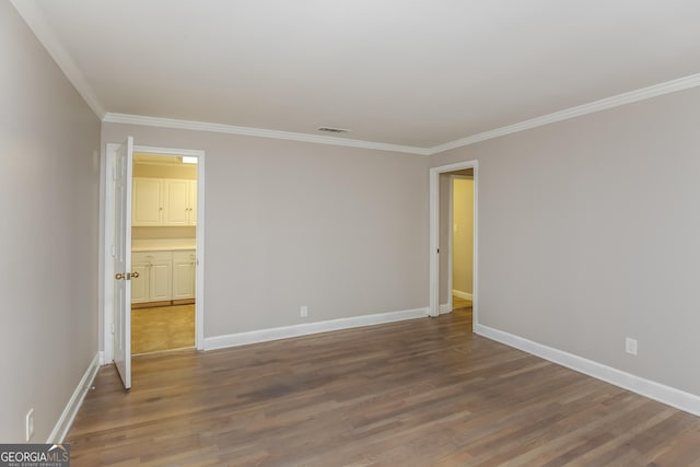 spare room with ornamental molding and hardwood / wood-style flooring