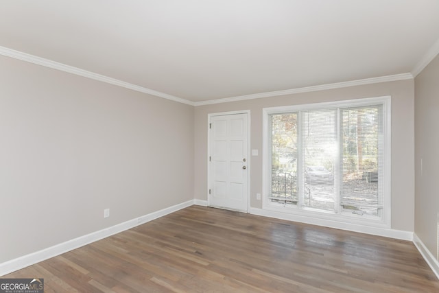 empty room with wood-type flooring and ornamental molding