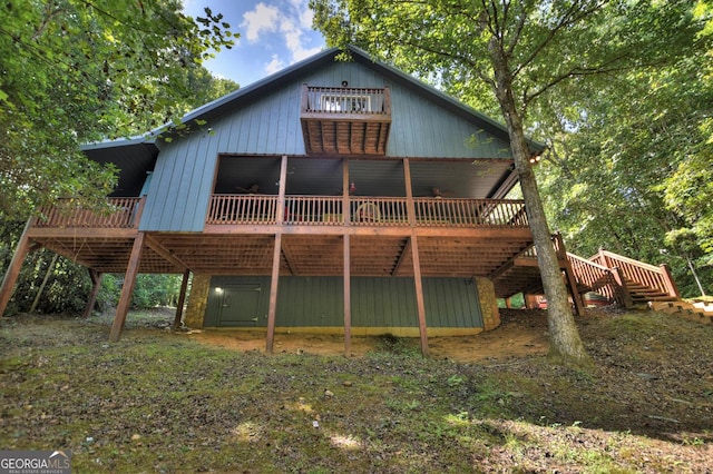 rear view of property featuring a deck and stairway