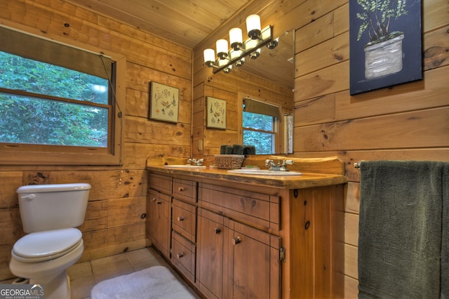 bathroom featuring vanity, wood walls, wooden ceiling, tile patterned floors, and toilet