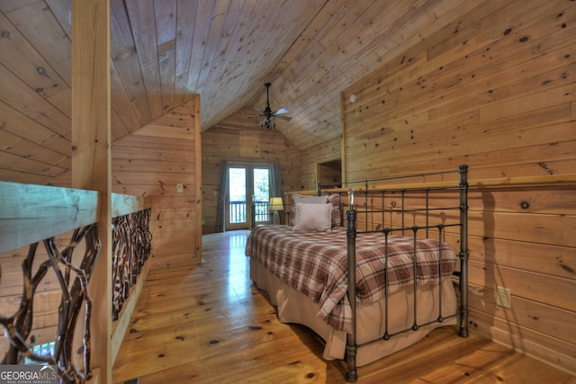 bedroom with wood ceiling, light hardwood / wood-style floors, wood walls, and lofted ceiling