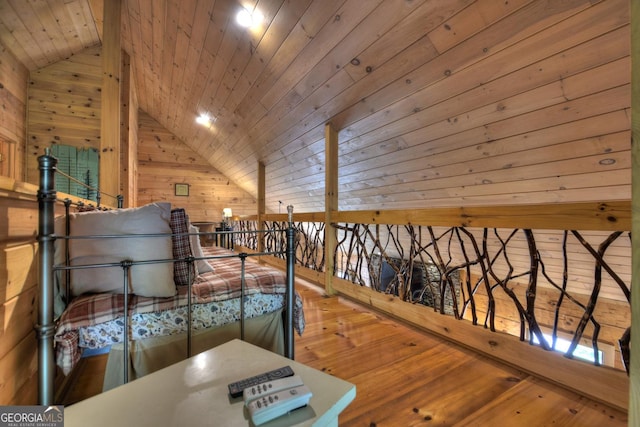 sitting room with lofted ceiling, hardwood / wood-style flooring, wood ceiling, an upstairs landing, and wood walls