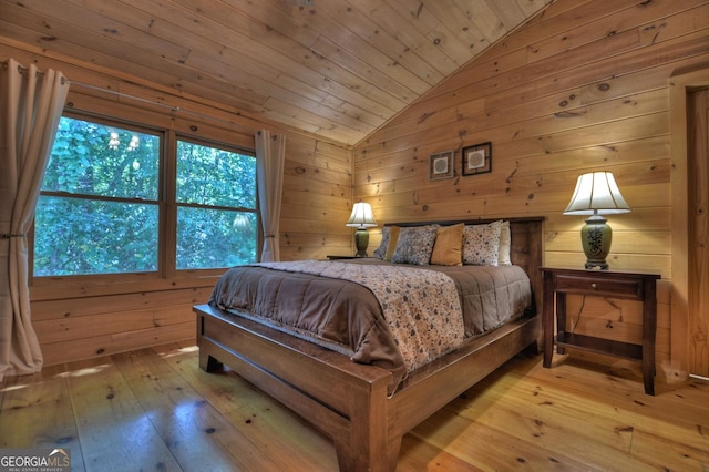 bedroom with light wood-type flooring, wood ceiling, vaulted ceiling, and wood walls