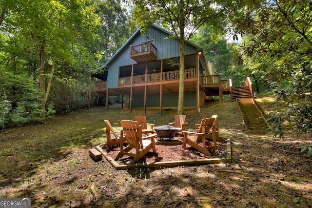 back of house featuring a fire pit, stairs, and a wooden deck