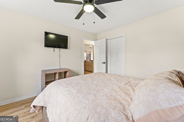 bedroom with ceiling fan, a closet, and light hardwood / wood-style floors