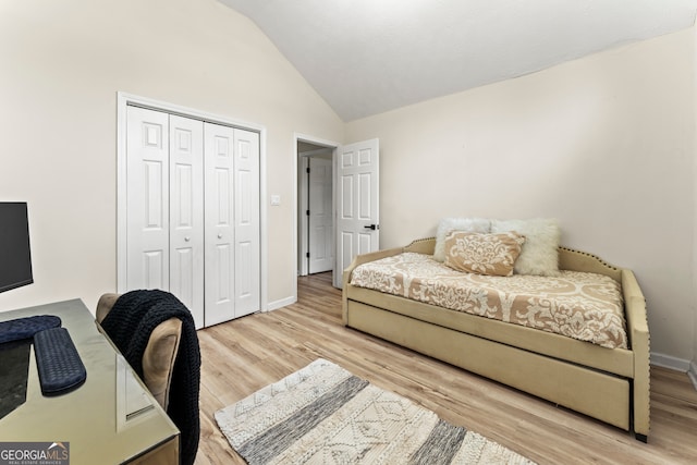 bedroom featuring vaulted ceiling, a closet, and light wood-type flooring