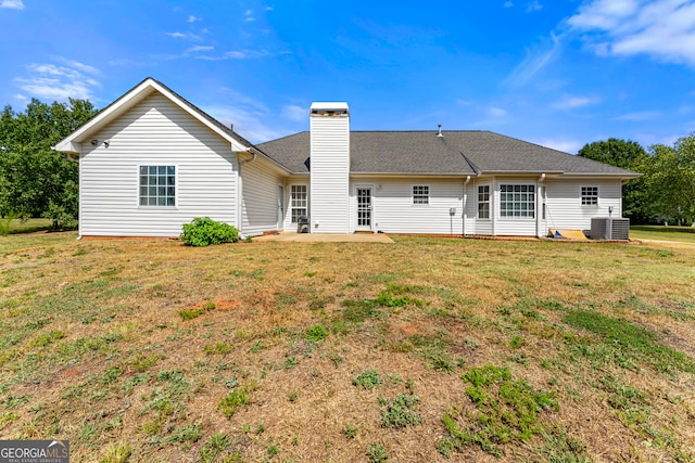 back of house with a lawn and central AC