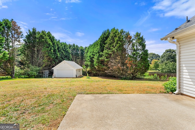 view of yard featuring an outdoor structure, a garage, and a patio area