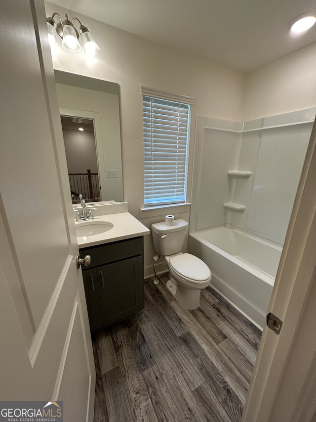 full bathroom with washtub / shower combination, hardwood / wood-style floors, toilet, and vanity