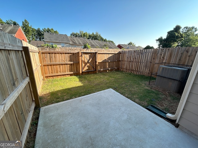 view of yard with central AC unit and a patio