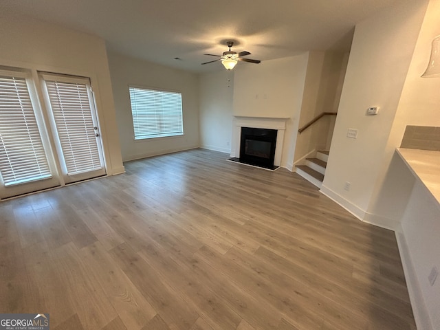 unfurnished living room featuring ceiling fan and wood-type flooring