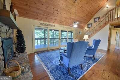 living room featuring wooden ceiling, a fireplace, high vaulted ceiling, hardwood / wood-style flooring, and ceiling fan