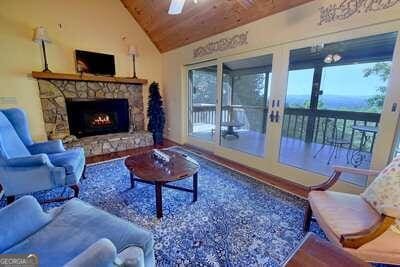 living room with lofted ceiling, wood ceiling, a wealth of natural light, and a fireplace