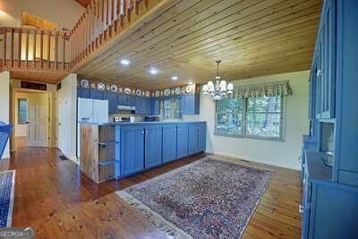 kitchen featuring white fridge, blue cabinetry, a chandelier, kitchen peninsula, and dark wood-type flooring