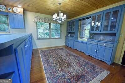 bar featuring wood ceiling, dark hardwood / wood-style flooring, a chandelier, pendant lighting, and blue cabinets