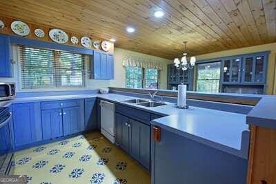 kitchen featuring wooden ceiling, a healthy amount of sunlight, stainless steel appliances, and a notable chandelier