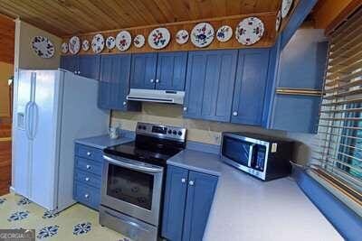 kitchen with wooden ceiling, stainless steel appliances, and blue cabinetry