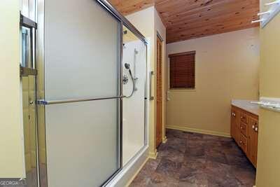 bathroom featuring wood ceiling, an enclosed shower, and vanity