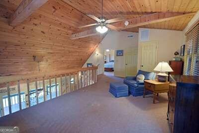 interior space with beamed ceiling, wooden ceiling, carpet, high vaulted ceiling, and ceiling fan