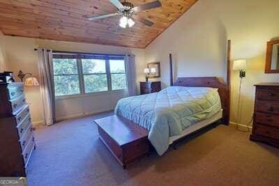 bedroom with lofted ceiling, carpet flooring, ceiling fan, and wood ceiling