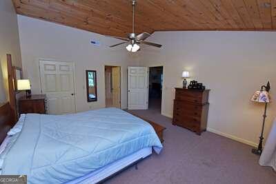 bedroom featuring carpet, vaulted ceiling, ceiling fan, and wood ceiling