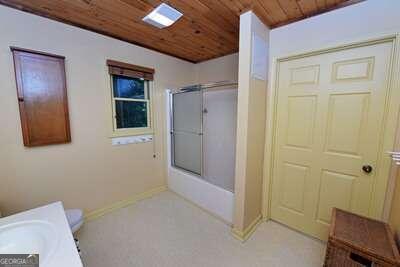 bathroom featuring wood ceiling and toilet