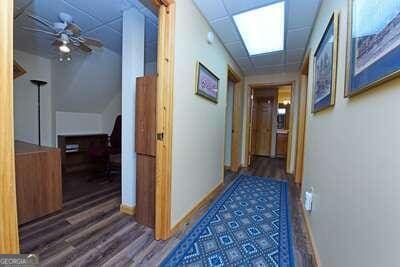 hall with hardwood / wood-style flooring and a paneled ceiling