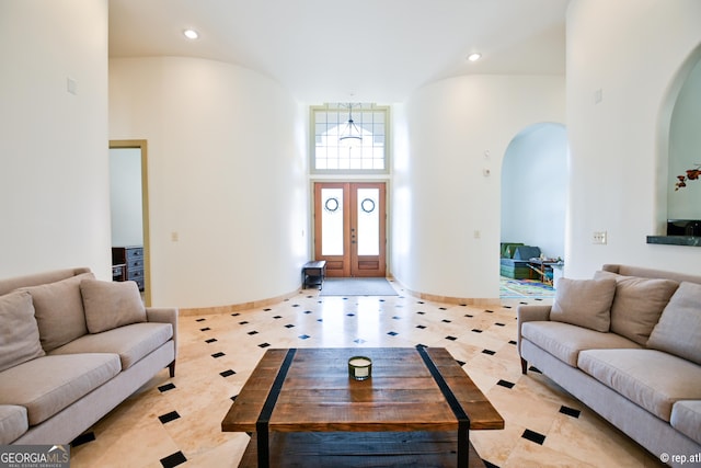 living room featuring light tile patterned flooring, a high ceiling, and french doors