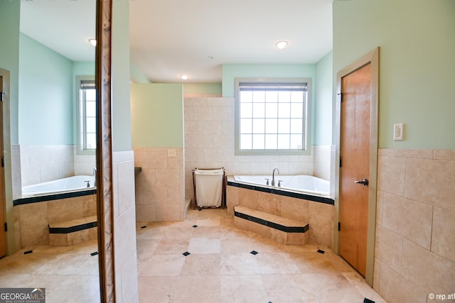 bathroom featuring tile patterned floors, tiled bath, and tile walls