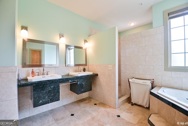 bathroom with tile patterned flooring, a healthy amount of sunlight, and tile walls