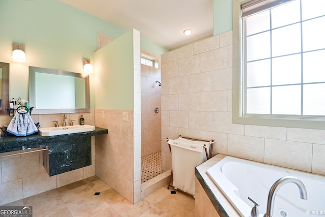 bathroom featuring separate shower and tub, sink, a wealth of natural light, and tile walls